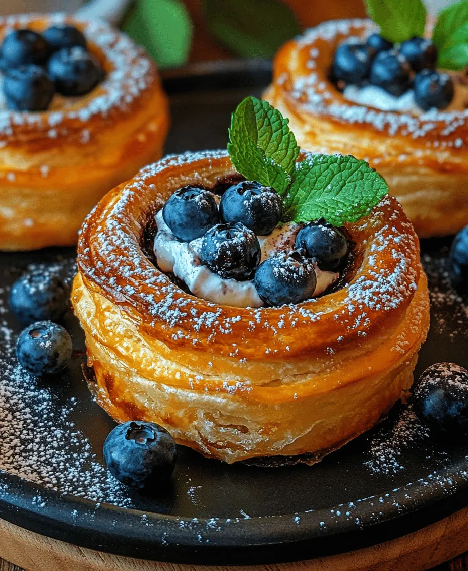 Welcome to the delightful world of pastries, where every bite transports you to a realm of sweetness and satisfaction. Pastries are celebrated for their versatility and charm, ranging from flaky croissants to decadent éclairs. They can grace your breakfast table, serve as an afternoon treat, or become the centerpiece of a special occasion. Today, we’re diving into a truly captivating dessert: Blueberry Pastry Rings with Vanilla Cream Filling. This recipe is a perfect representation of the magic that can happen when you combine the tartness of fresh blueberries with the rich, velvety texture of vanilla cream.